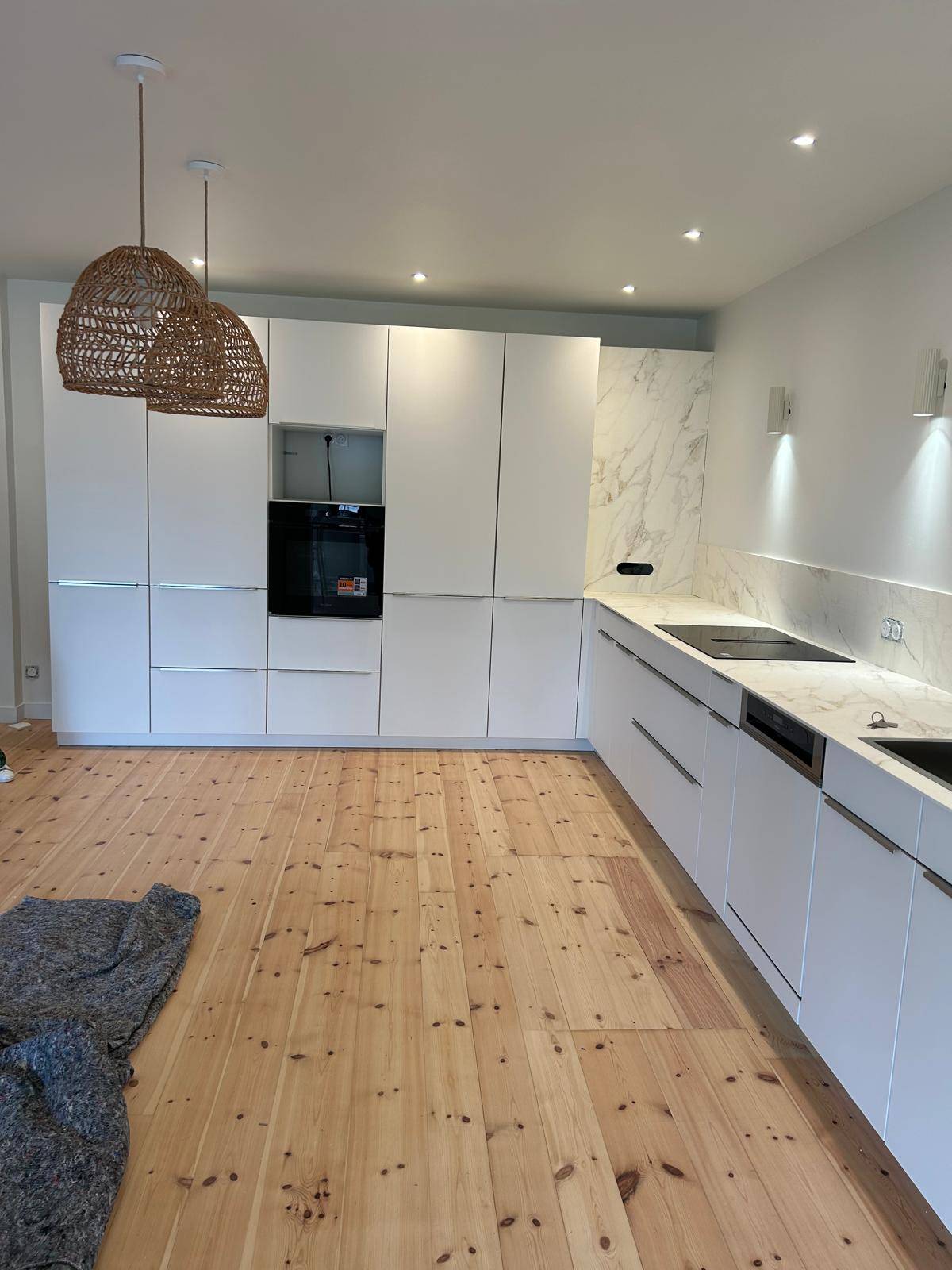 Rénovation d'une cuisine au Havre : pose d'une grande cuisine blanche avec plan de travail marbre blanc