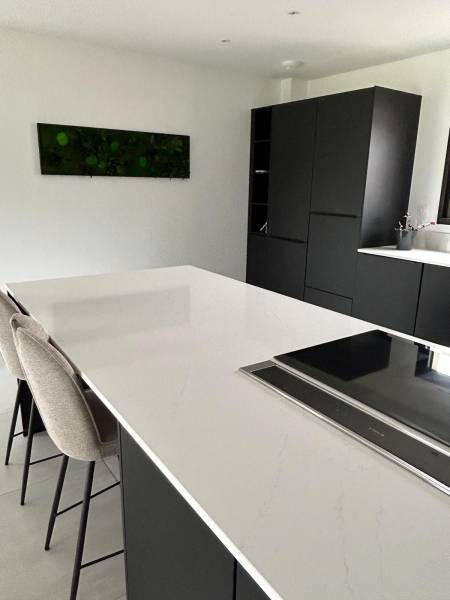 Création d'une cuisine noir et blanche avec îlot central et plan de travail en pierre naturelles blanche au Havre 76600 en Normandie
